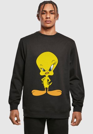Fekete kapucnis pulóver, amelyen elöl egy nagy, rajzfilmszerű sárga Tweety Bird grafika található. Puha anyagból készült, kerek nyakkivágással.