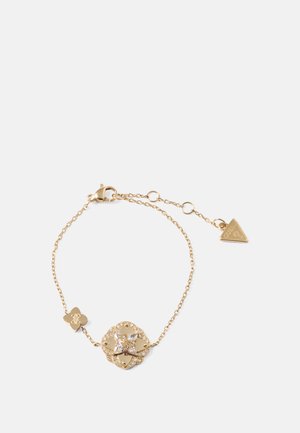 Gold chain bracelet with a floral pendant featuring a central crystal, accented by a smaller flower charm and a triangular tag.