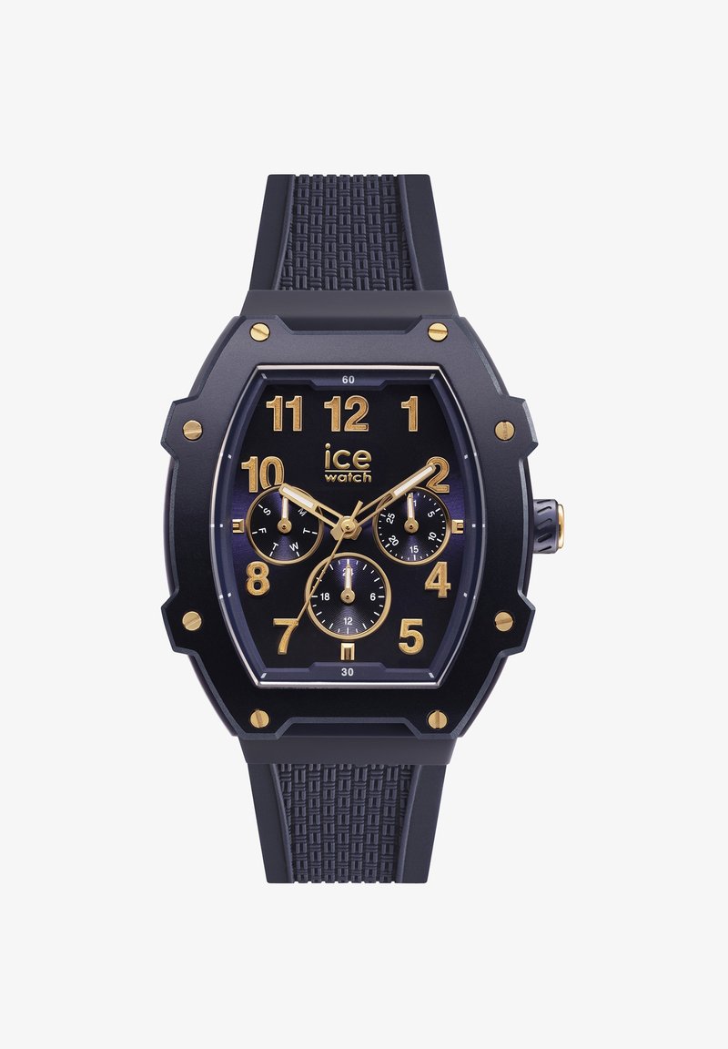 Orologio con cinturino in gomma nera, caratterizzato da una cassa ottagonale, numeri dorati e tre sottoquadranti. Cinturino testurizzato con dettagli dorati e quadrante scuro.