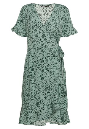 Grünes Wickelkleid mit Punkten, kurzen Flatterärmeln, V-Ausschnitt, Bindegürtel und einem gerüschten Saum. Leichte Stofftextur.