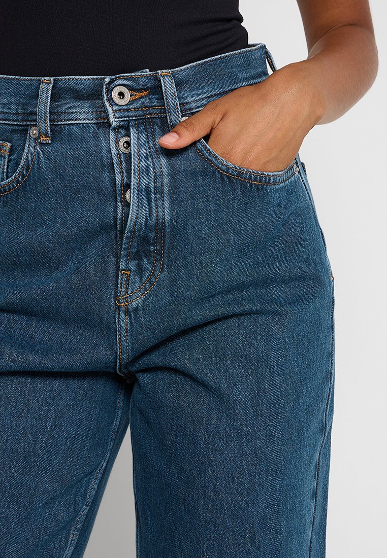 Hoge taille blauwe denim jeans met een rechte snit, vijf zakken en contrasterende stiksels. Vastgemaakt met een knoop en rits.