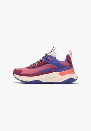 Multicolored sneaker featuring pink, purple, and orange panels, textured fabric, chunky cream sole, and a prominent logo on the side.