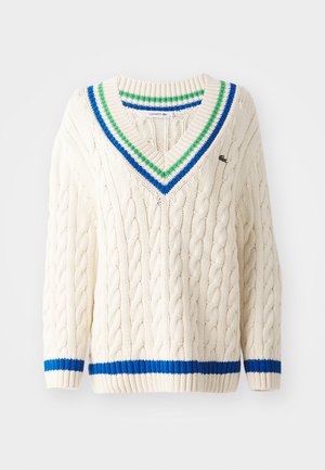 Crème kleurige kabelgebreide trui met een V-hals, voorzien van groene, blauwe en witte gestreepte accenten op de kraag en manchetten. Klassiek sportief design.