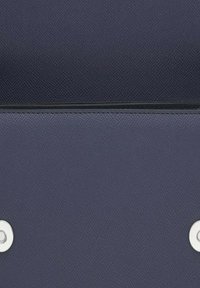 Cartera de cuero texturizado azul marino con dos botones a presión plateados, que presenta un borde superior liso y un detalle de costura en la parte inferior.