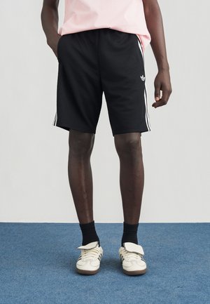 Pantaloncini atletici neri con un design in mesh testurizzato, caratterizzati da tre strisce bianche lungo i lati e un logo ricamato sulla gamba.