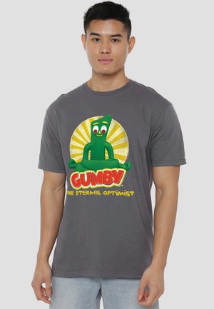 Gray cotton t-shirt featuring a green Gumby graphic, with vibrant colors and text stating "GUMBY THE ETERNAL OPTIMIST." Simple crew neck design.