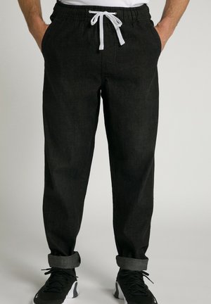 Pantalones jogger de denim negro con cintura elástica, cordón blanco y puños enrollados. Presentan una textura suave y un ajuste relajado.