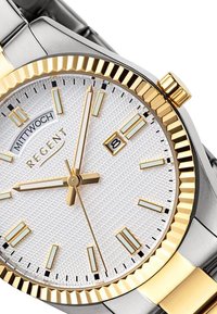 Montre en acier inoxydable argent et or avec un cadran blanc texturé, des aiguilles dorées et un affichage de la date. Elle est dotée d'une lunette dorée cannelée.