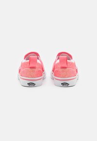 Zapatos brillantes de color rosa con acentos blancos, suelas planas, tela texturizada y un tirador en la parte posterior; presenta el logo "Vans Off The Wall".
