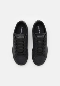 Czarne skórzane sneakersy o niskim profilu, okrągłym nosku, z perforowanymi akcentami i czarnymi sznurowadłami. Logo Lacoste w kolorze srebrnym na języku buta.