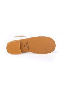 Suela de zapato con una base de goma marrón texturizada, con forma redondeada y borde reforzado. Detalles de tamaño y marca impresos visibles.