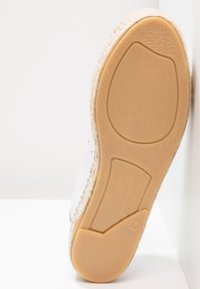 Vit espadrille med en strukturerad beigefärgad sula, jutedetaljer längs kanten och en slät yta. Storlek 8,5 markerad på sulan.