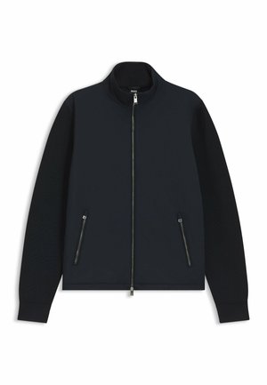 Schwarze Jacke mit durchgehendem Reißverschluss, Stehkragen, langen Ärmeln, zwei vorderen Reißverschlusstaschen und gerippten Bündchen.