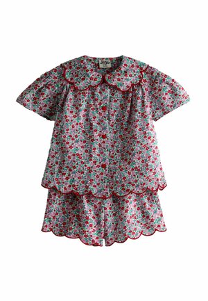 Detský dvojdielny kvetinový outfit s červenými, ružovými a zelenými kvetmi, lemovaný vlnkovanými okrajmi a červeným lemovaním na golieri, rukávoch a šortkách.