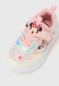 Baskets rose clair à pois, avec un motif Minnie Mouse, une bride brillante et une tige en tissu texturé. Semelle blanche avec des détails.