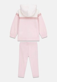 Felpa con cappuccio rosa chiaro con dettagli bianchi e fascia con logo, abbinata a leggings rosa chiaro coordinati. Tessuto morbido, design con cappuccio, vita elasticizzata.