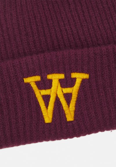 Mörkröd stickad mössa med ribbad textur, prydd med en broderad gul "W"-logotyp framtill. Mjuk ullmaterial.