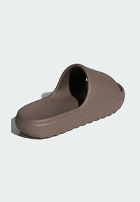 Brown foam slide sandal with a wide open top, contoured footbed, textured sole, and embossed brand logo on the side.