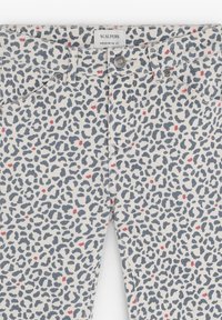 Pantaloni din denim alb cu un model de leopard în nuanțe de albastru și roz, având fermoar, închidere cu nasture și cinci buzunare.