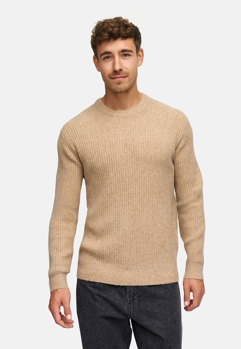 Pullover a coste beige con maniche lunghe e scollo a girocollo, abbinato a jeans in denim scuro, con una consistenza morbida.