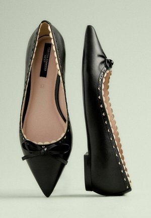 Melnas ādas baleta kurpes ar norādītām pirkstu daļām, viļņotām malām, mazu loku priekšā un zemu papēdi. Gluda tekstūra un smalka apdare.