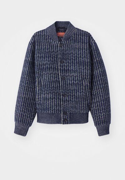 Μπλε ναυτικού πλέκτο καρφίτσα με σχέδιο βελόνας, με ριμπ κολλάρο, μανσέτες και στρίφωμα. Διαθέτει μαύρα κουμπιά κατά μήκος του μπροστινού μέρους.