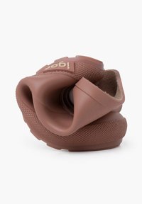 Chaussure en caoutchouc brun avec une semelle texturée, une forme contourée, un design flexible et une partie supérieure en boucle. Présente un logo en relief sur le côté.