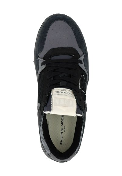 Sneaker nera e grigia con lacci neri, punta perforata, etichetta bianca sulla lingua che legge "Philippe Model Paris" e colletto imbottito.