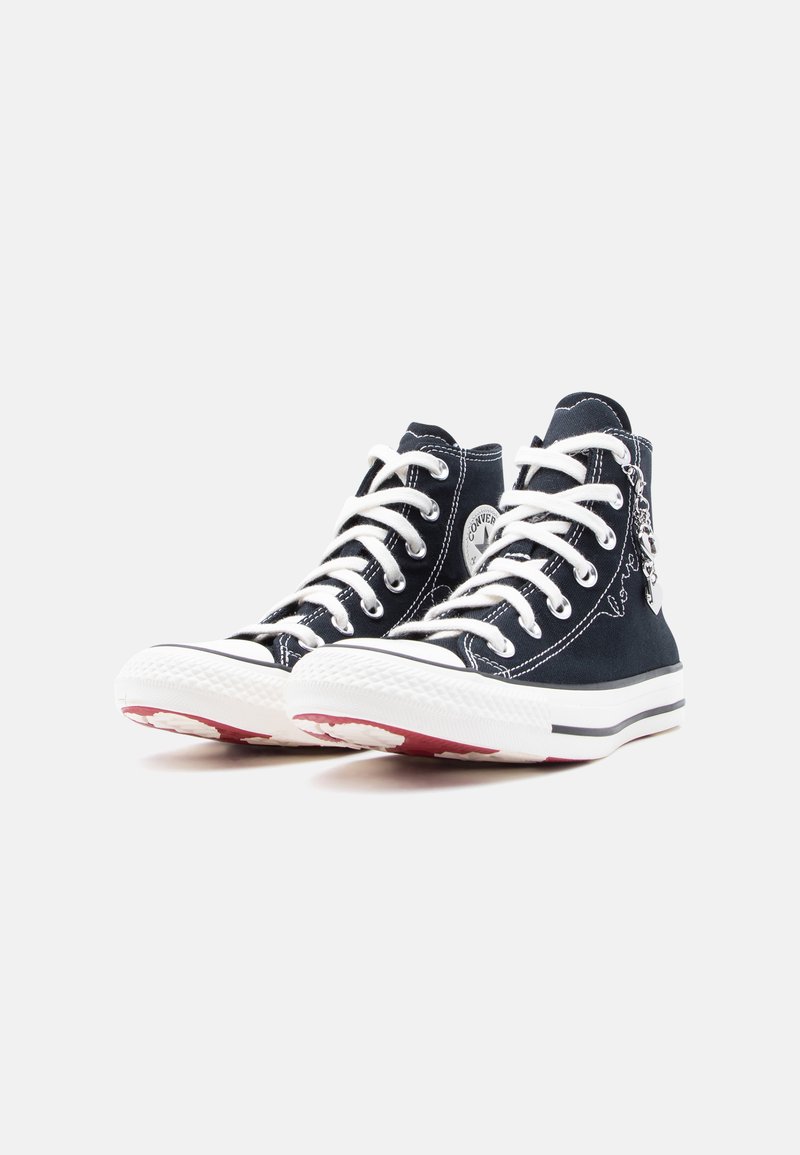 Coppia di sneakers Converse nere alte con lacci e suole bianche, viste da un angolo anteriore sinistro su sfondo bianco.