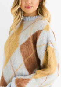 Multicolored knitted sweater featuring a light blue, yellow, and brown argyle pattern. Soft, fuzzy texture and a ribbed neckline.