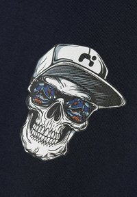 Grafika lebky s modrými slunečními brýlemi odrážejícími barevné ryby, na hlavě má bílou čepici. Grafika je vytištěna na tmavě námořnickém látkovém podkladu.