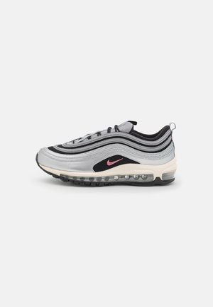 Tenisky Nike Air Max 97 s metalickým stříbrným svrškem, černými akcenty, síťovinovými detaily a růžovým logem. Mají viditelnou vzduchovou polstrovanou podrážku.