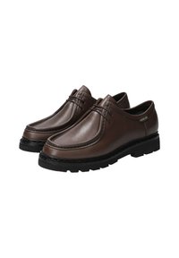 Des chaussures en cuir marron au design mocassin, dotées de lacets, d'une semelle en caoutchouc noir et d'un piquage détaillé sur le bord.