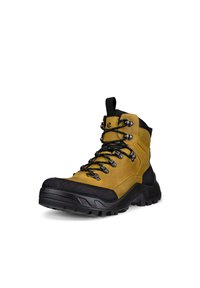 Gul vandringskänga med svart gummitå och sula. Har metallöglor, snörningar och en dragrem, tillverkad av strukturerat syntetmaterial.