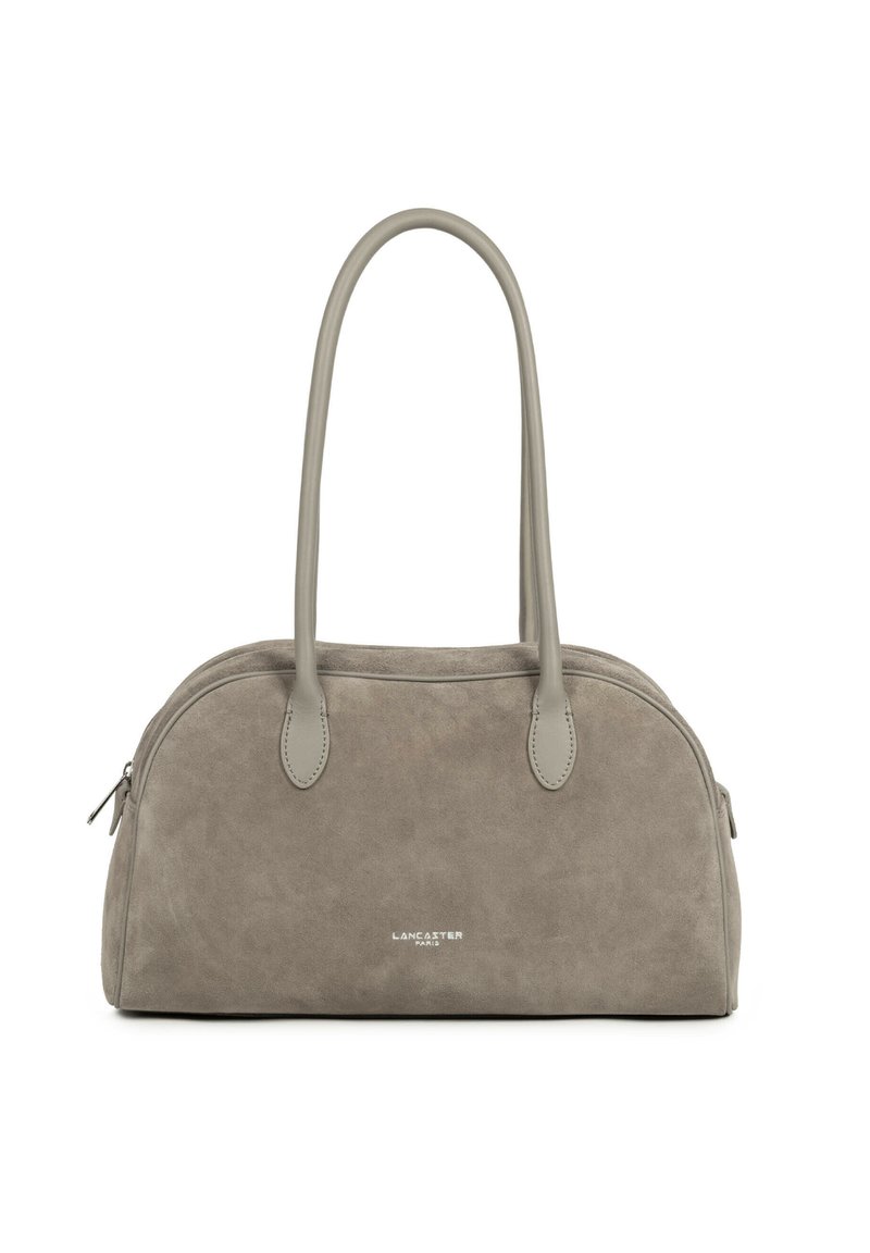 Sac à main en daim gris de forme arrondie, avec deux poignées supérieures et une fermeture éclair. Présente un logo embossé sur le devant et des accents lisses.