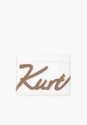 Biały etui na karty z brązowym haftowanym logo w formie kursywy, na którym napis „Kurt” znajduje się z przodu.
