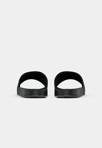 Pair of black open-toe slide sandals with wide straps, viewed from the front on a plain white background.