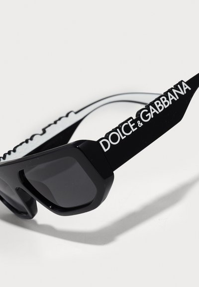 Melni saules brilles ar masīvu, kvadrātu veidolu. Ar spīdīgu apdari un tumšiem stikliem. Akcentētas ar "DOLCE & GABBANA" baltā krāsā uz kājiņas.