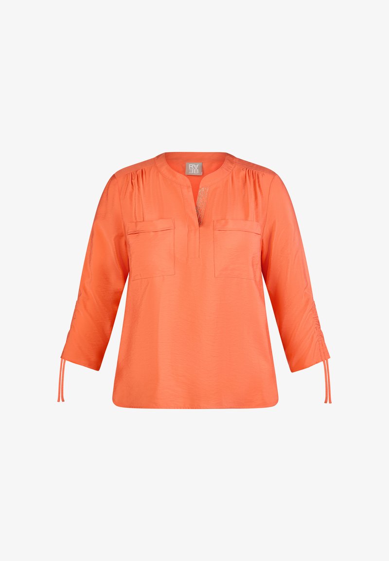 Helles orange Bluse mit Dreiviertelärmeln, Rundhalsausschnitt, zwei vorderen Taschen und raffinierten Details an Schultern und Ärmeln.