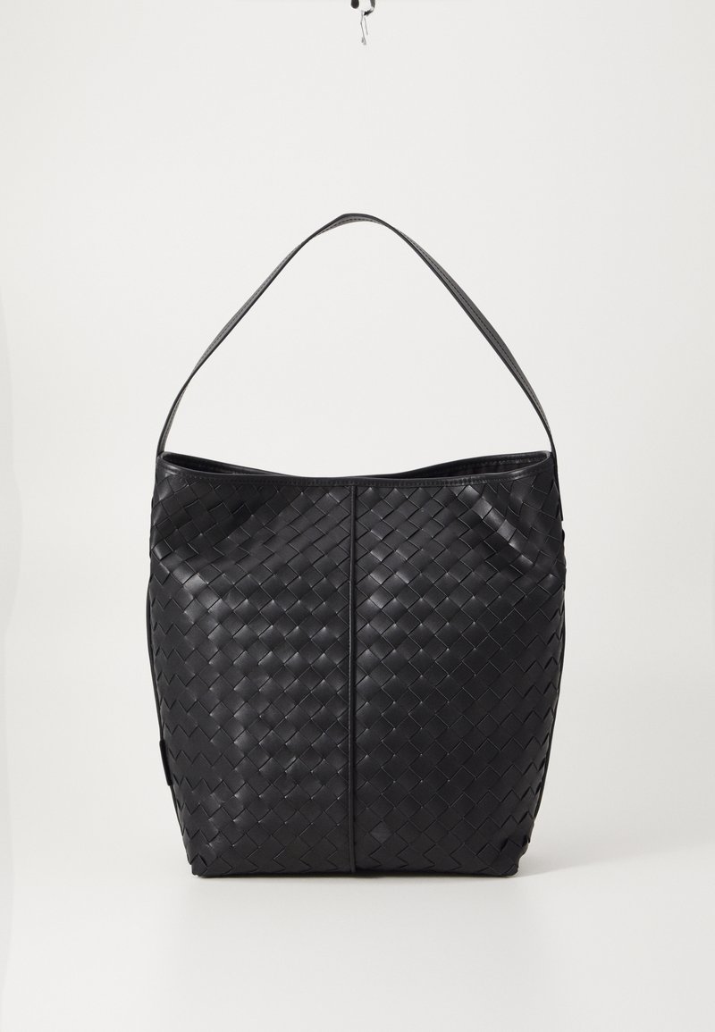 Sac en cuir tressé noir avec un haut ouvert, une bandoulière unique et une finition lisse. Présente un motif texturé et une forme douce et arrondie.