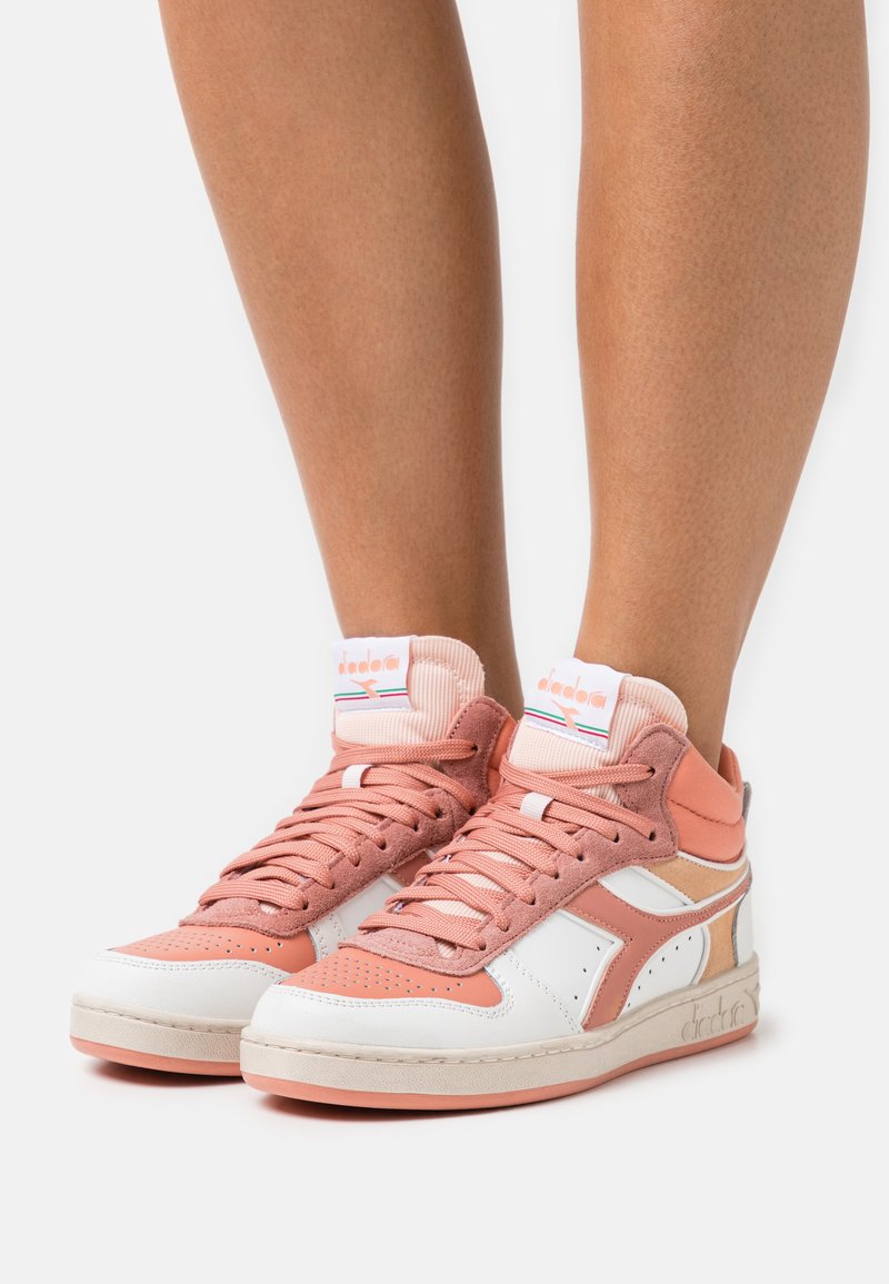 Sneaker alte in rosa chiaro e bianco, caratterizzate da una miscela di pelle liscia e morbido suede, punta arrotondata e colletto imbottito con dettaglio del logo.
