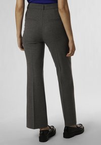 Gray flared trousers with a textured fabric, featuring two back pockets and a high waist. Paired with black shoes, showing a smooth surface.