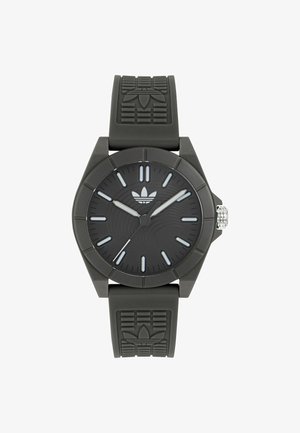 Čierne analógové hodinky s textúrovaným gumovým remienkom, okrúhlym púzdrom a tromi striebornými ručičkami. Na remienku je vyrazené logo.