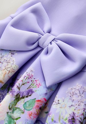 Laventeli kankaan kaari kukkakuosisella kankaalla, jossa on vaaleanpunaisia, valkoisia, violetteja kukkia ja vihreitä lehtiä pehmeissä pastelliväreissä.