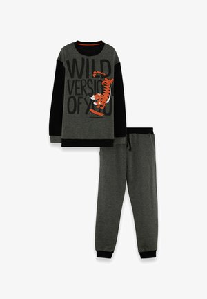 Mørkegrå og sort puslesæt til børn med en tiger på skateboard og teksten "VILD VERSION AF DIG" på trøjen.