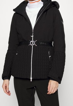 Giacca isolante nera con zip frontale, dettagli bianchi, maniche texturizzate, vita con cintura e cappuccio staccabile con pelliccia sintetica.