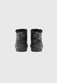 Botine negre de iarnă cu manșete căptușite cu blană și branding "Bogner", prezentate din spate pe un fundal alb simplu.