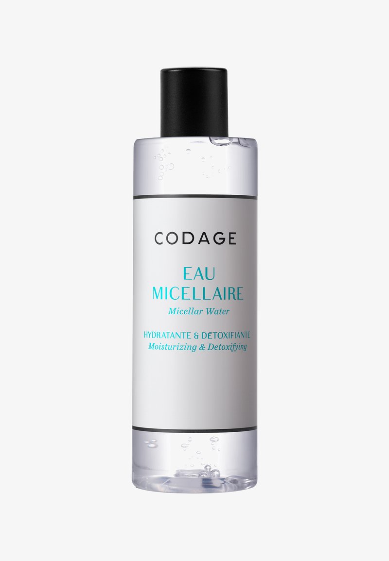 Transparent bottle of micellar water with a black cap, cylindrical shape, featuring a white label with black and turquoise text.