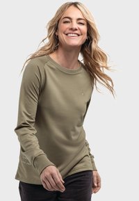 Olivenfarbener Langarmshirt aus weichem Stoff mit rundem Halsausschnitt und gerippten Bündchen, mit einem kleinen Logo auf der oberen linken Seite und Text am Ärmel.