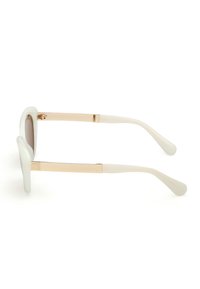 Białe okulary przeciwsłoneczne z solidnym plastikowym ramieniem, złotymi metalowymi akcentami na zausznikach oraz gładką fakturą. Soczewki są w odcieniu brązowym.